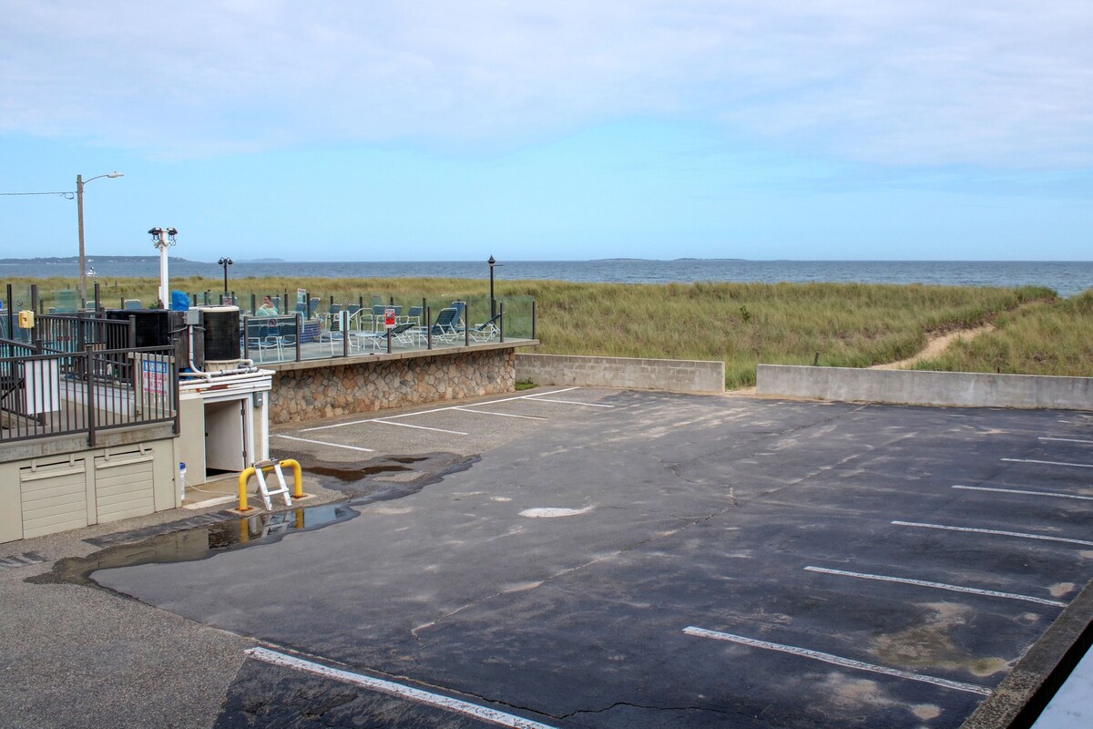 A parking area with a view of the beach and ocean.