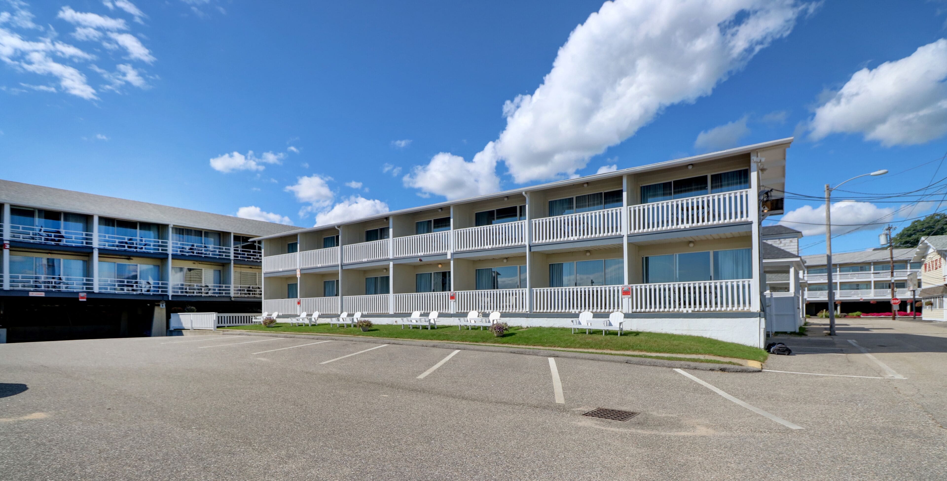 A multi-story hotel with a parking lot in front.
