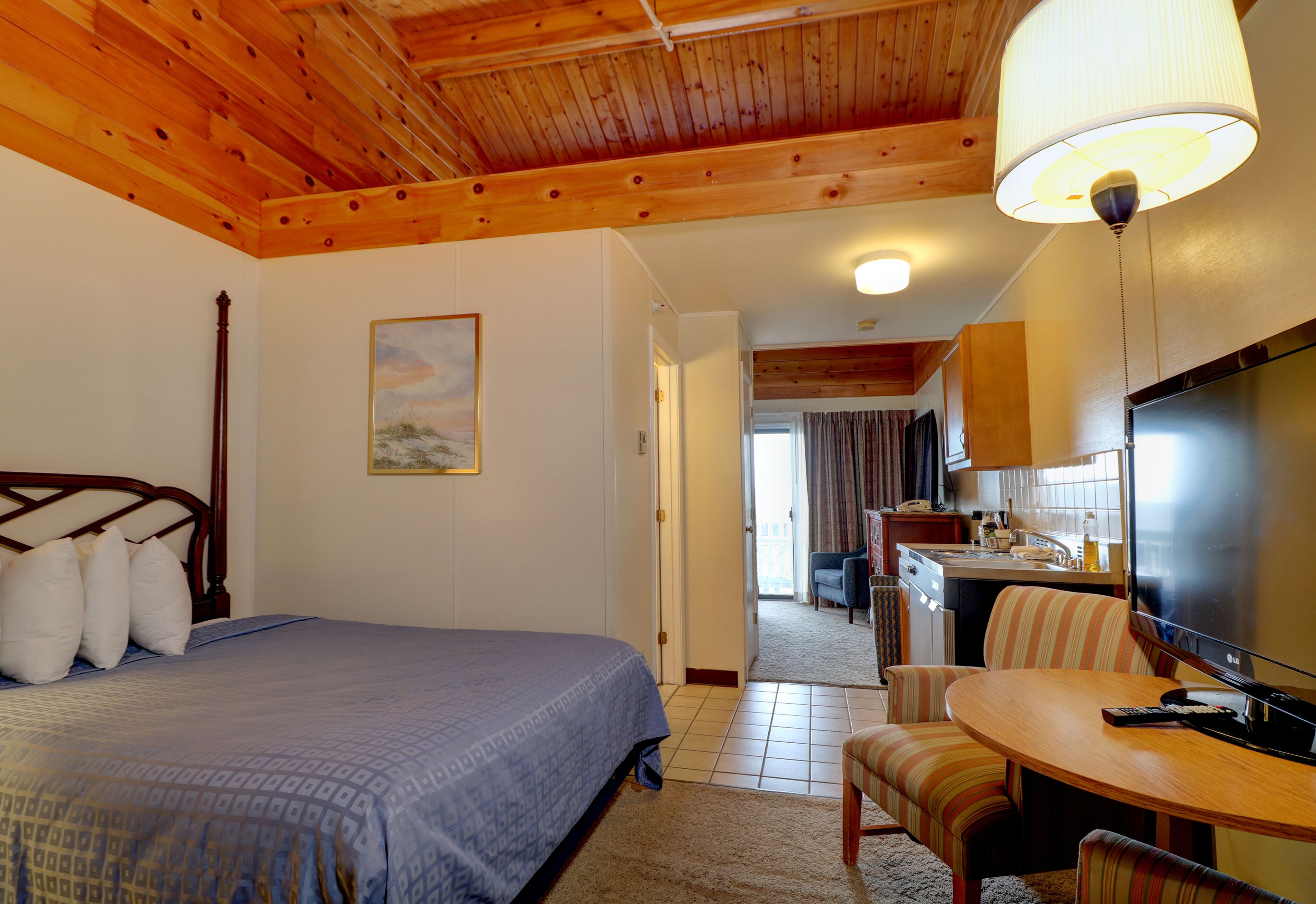 Ein Schlafzimmer mit Bett, Schreibtisch und Fernseher.