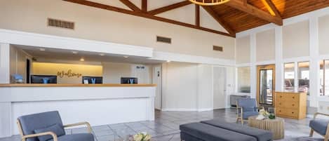 A spacious lobby with a reception desk, seating area, and a chandelier.
