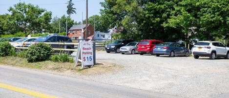 A parking lot with a sign indicating all-day beach parking at $15.