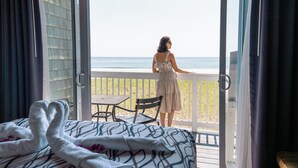Una habitación con cama, balcón y vista al mar.