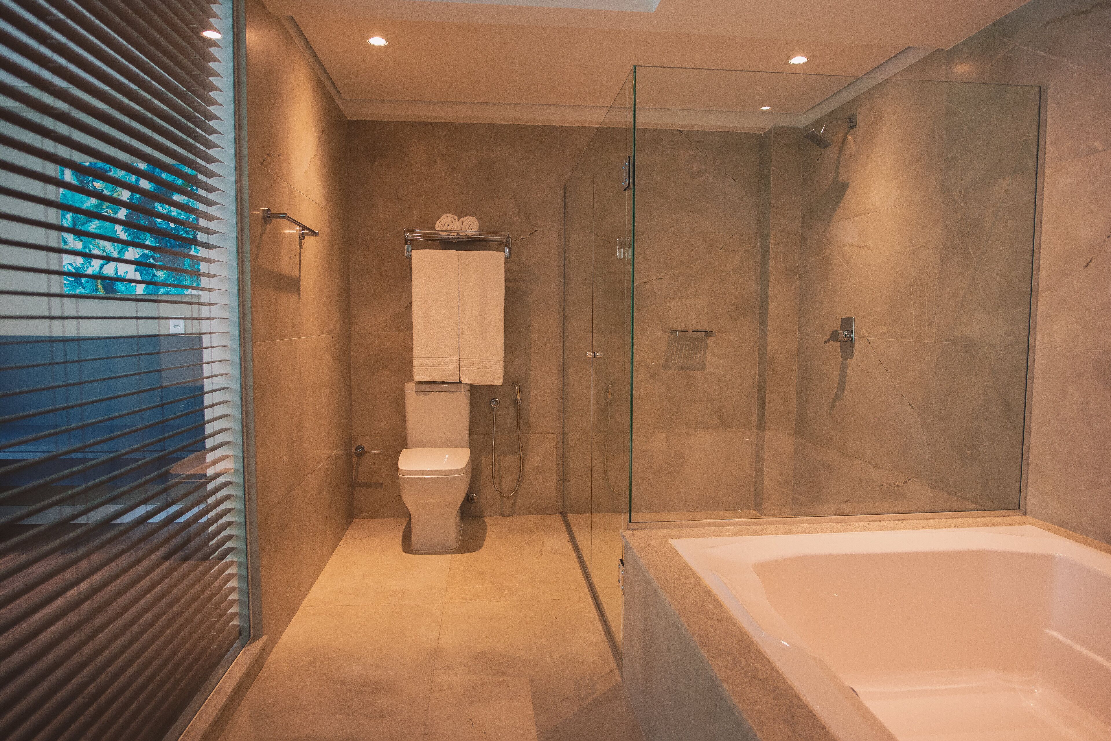 Un baño moderno con ducha de vidrio, inodoro independiente y bañera separada.