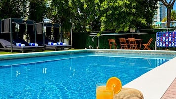 Una piscina al aire libre, camas de piscina gratis, sombrillas
