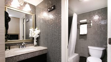 A bathroom with a sink, mirror, and toilet.