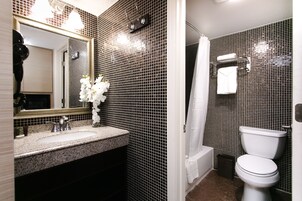 Un baño con lavabo, espejo e inodoro.