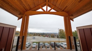 A covered parking area with a view of a road and parked cars.
