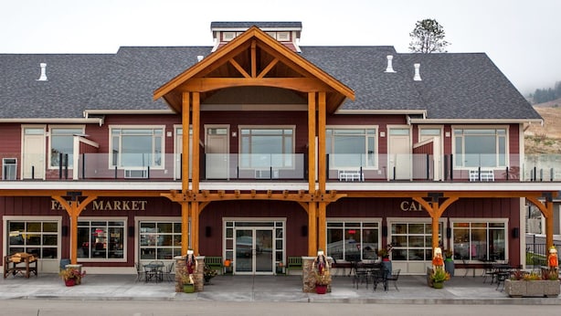 A two-story building with a wooden facade and large windows.