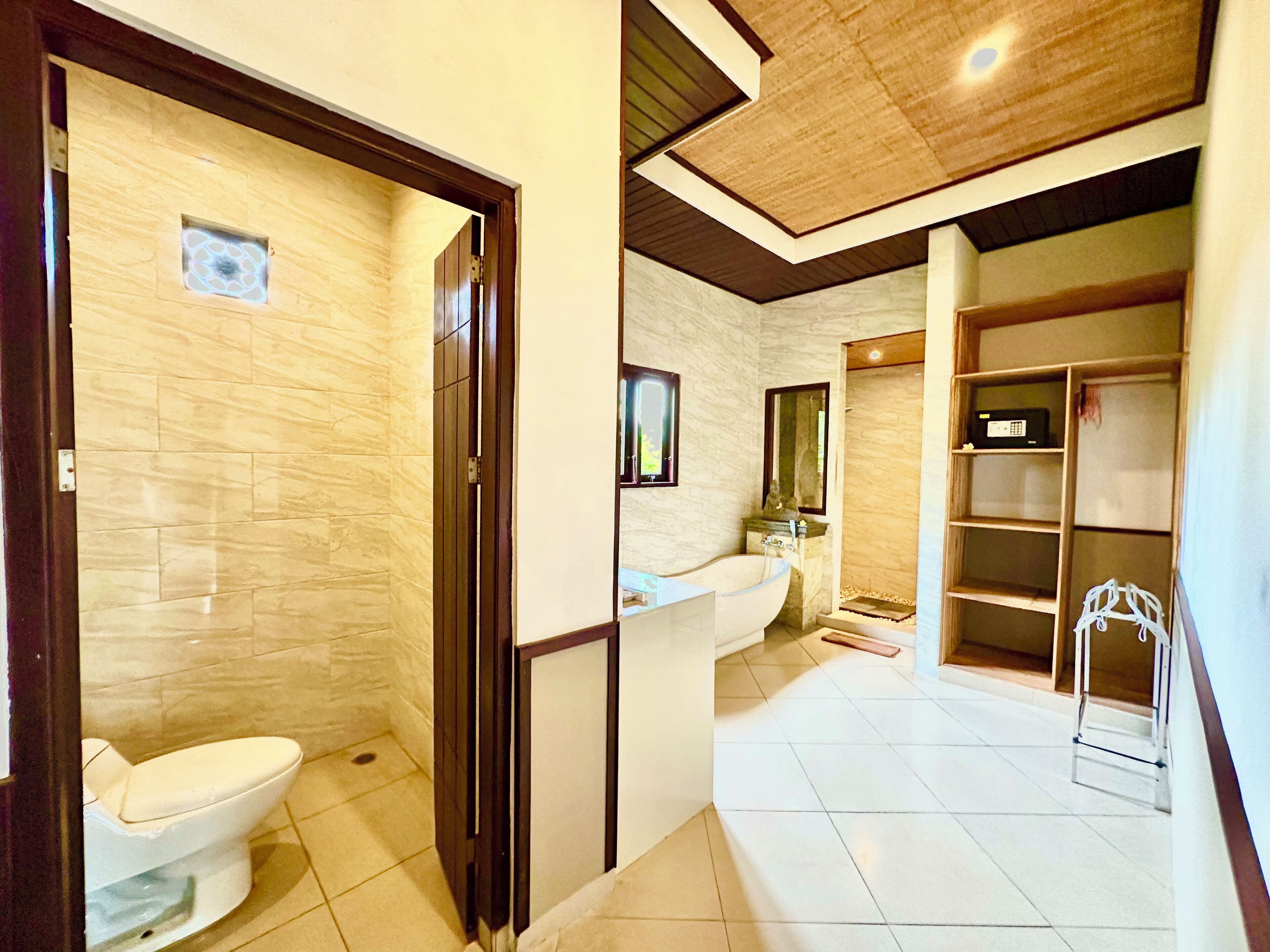 A bathroom with a toilet, a bathtub, and a shower area.