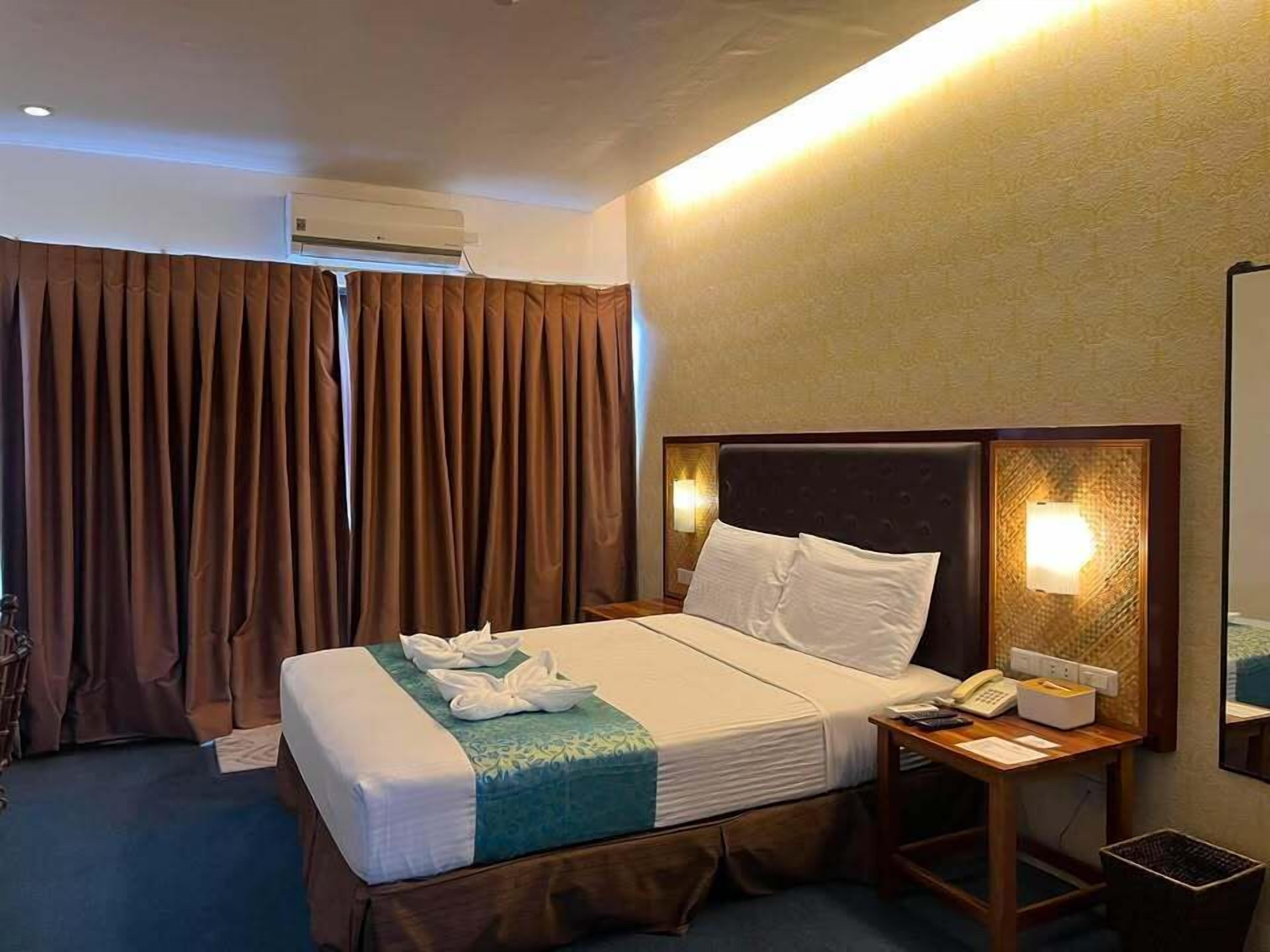 Une chambre d’hôtel équipée d’un lit, d’une table de chevet, d’une lampe et d’un appareil de climatisation.