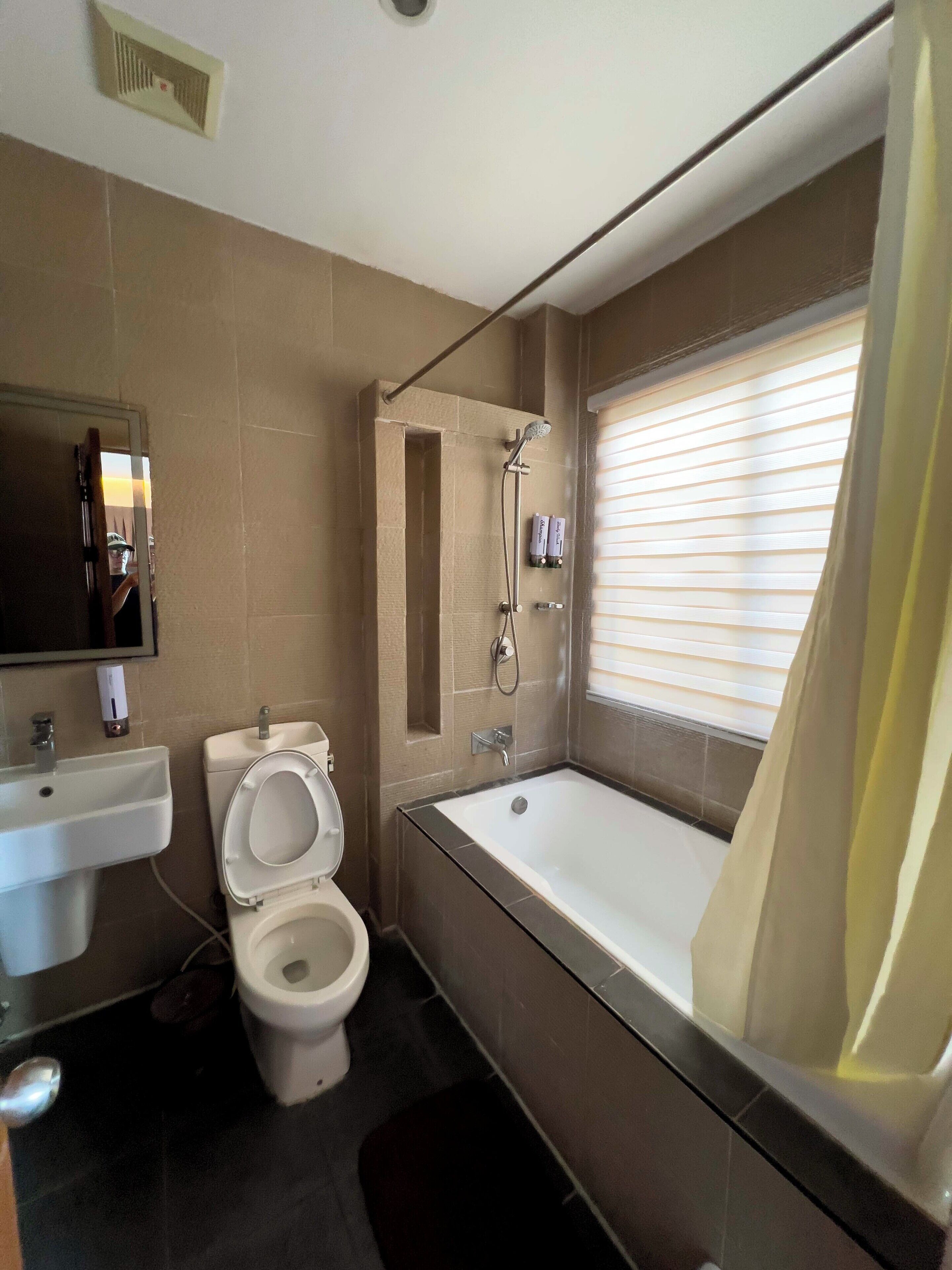 A bathroom with a toilet, sink, bathtub, and shower.