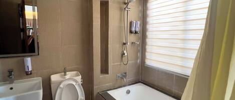 A bathroom with a toilet, sink, bathtub, and shower.