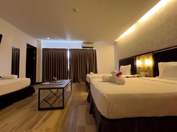 A hotel room with two beds, a small table, and a nightstand. - Aozora Seaside Mactan (Lapu-Lapu)