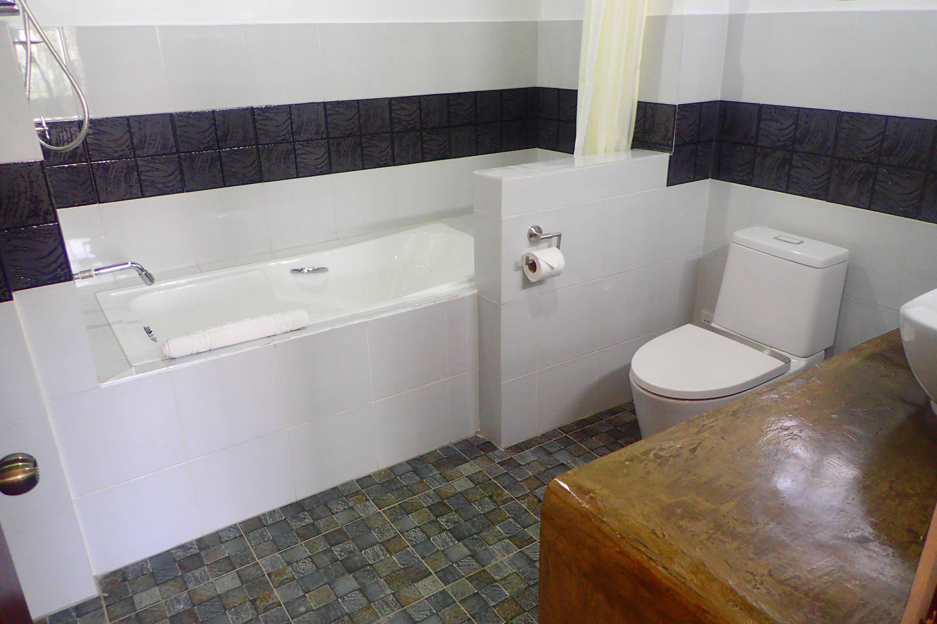 A bathroom with a bathtub, toilet, and a sink.