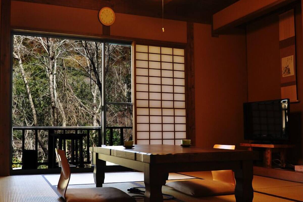 Une pièce de style japonais traditionnel, avec un sol recouvert de tatamis, une table basse et des portes coulissantes en papier de riz (shoji).