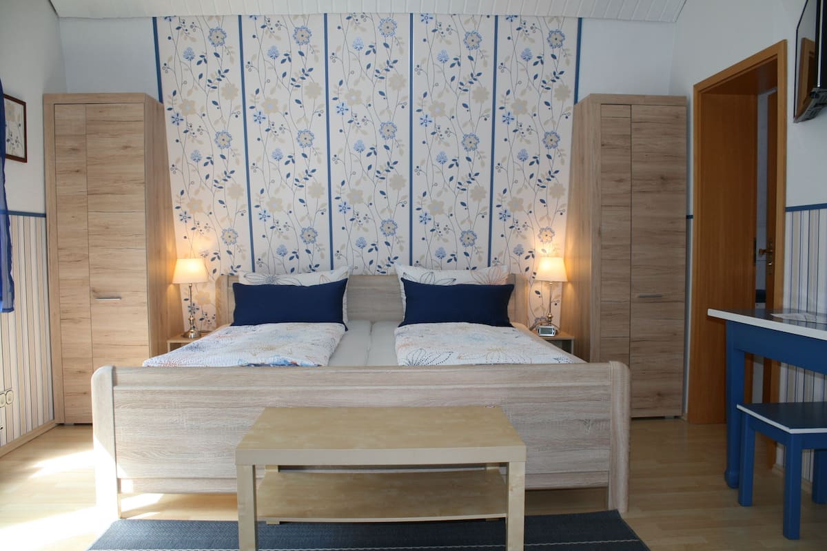 Ein Schlafzimmer mit einem hölzernen Bett, zwei Nachttischen und einem Beistelltisch.