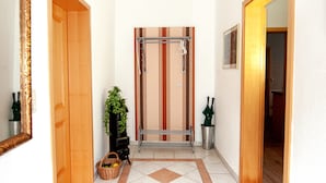 Un pasillo con piso estampado, una lámpara colgante y una puerta que da a una habitación.