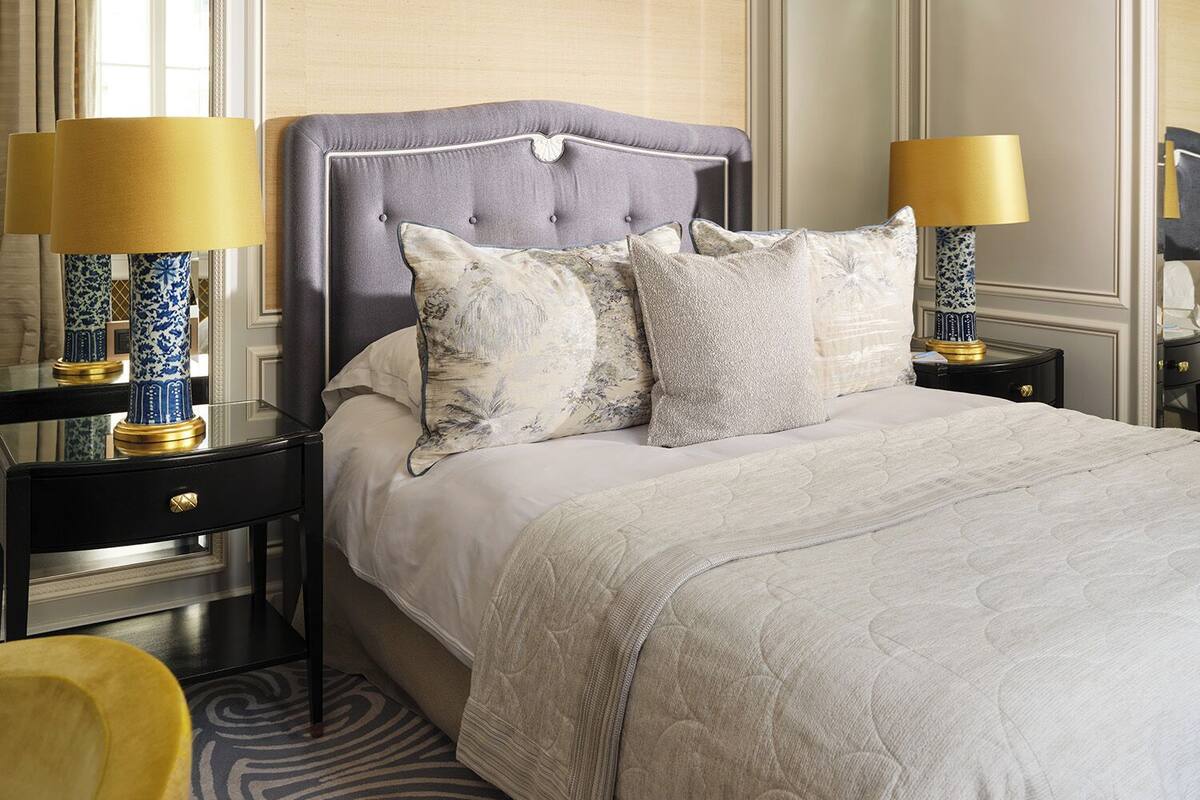 A neatly arranged bedroom with a large bed, two bedside tables, and matching lamps.