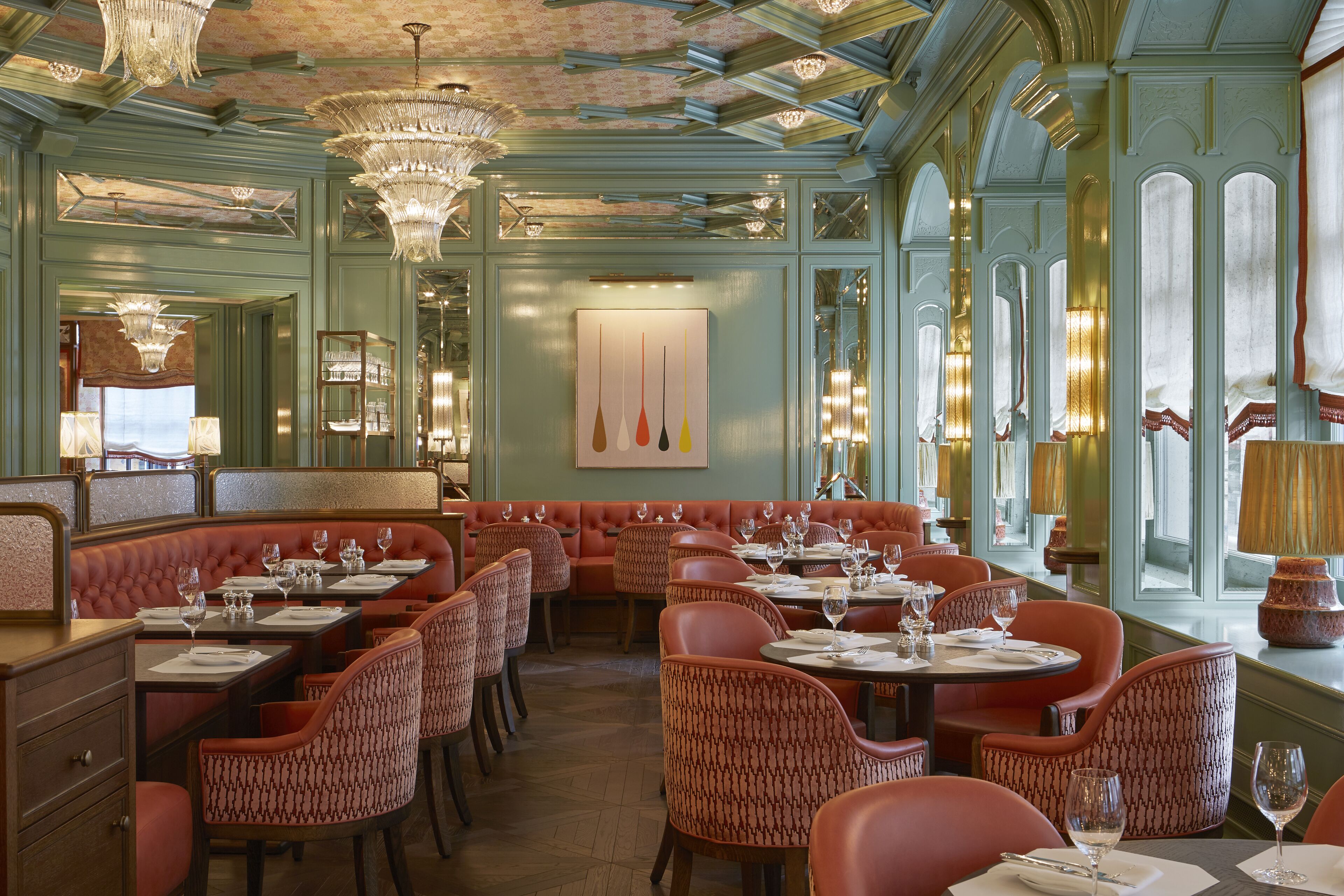 A restaurant with booths, round tables, and patterned chairs.