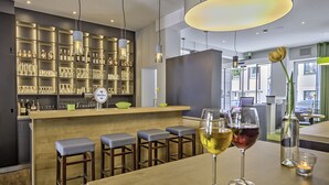 A bar area with stools, a counter, and bottles of alcohol. - Hotel zur Börse (Hamelin)