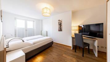 Una habitación de hotel moderna con cama, escritorio y televisor.