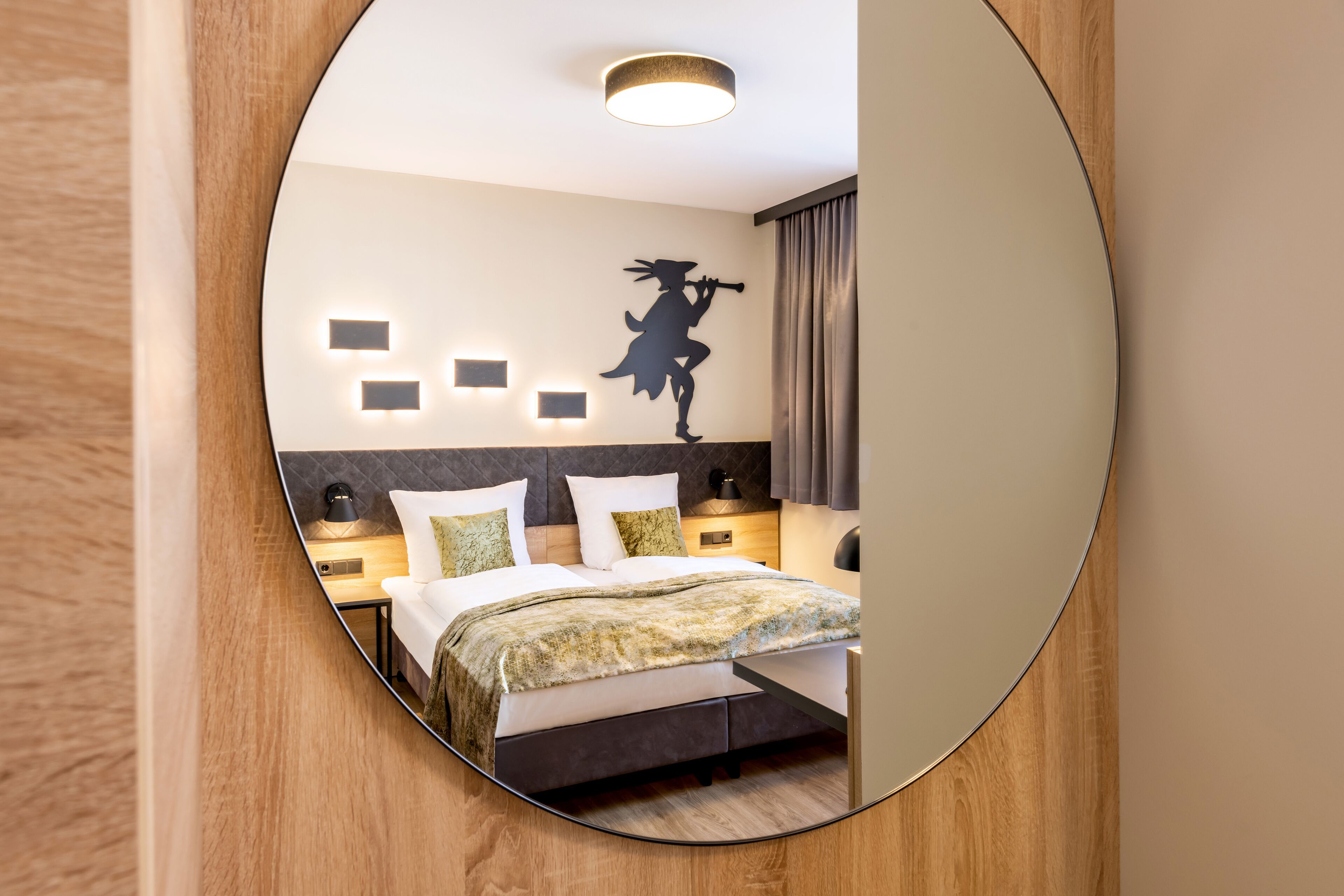 Ein modernes Schlafzimmer mit einem Bett, Nachttischen und einer wandmontierten Leuchte.