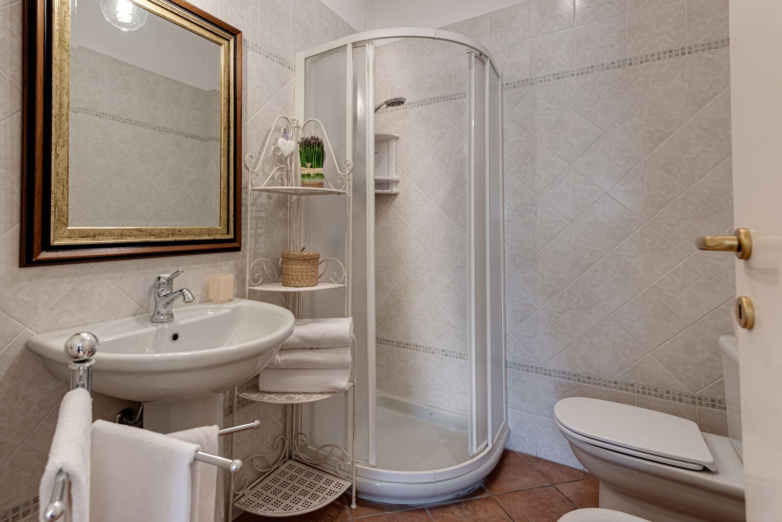 Un bagno con lavandino, WC e doccia.