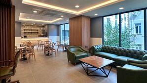 A modern interior with a dining area, seating, and a view of the outside. - Hotel Sapphire (Istanbul)