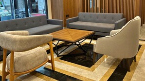 A modern lounge area with a sofa set, armchairs, and a coffee table. - Hotel Sapphire (Istanbul)