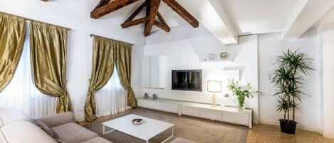 Una sala de estar moderna con un sofá, una mesa de centro, un televisor y una planta en maceta.