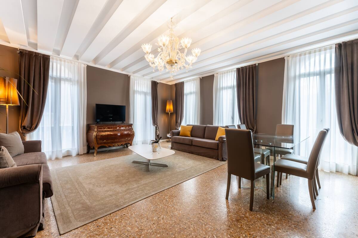 Een moderne woonkamer met een bank, salontafel en een eethoek.