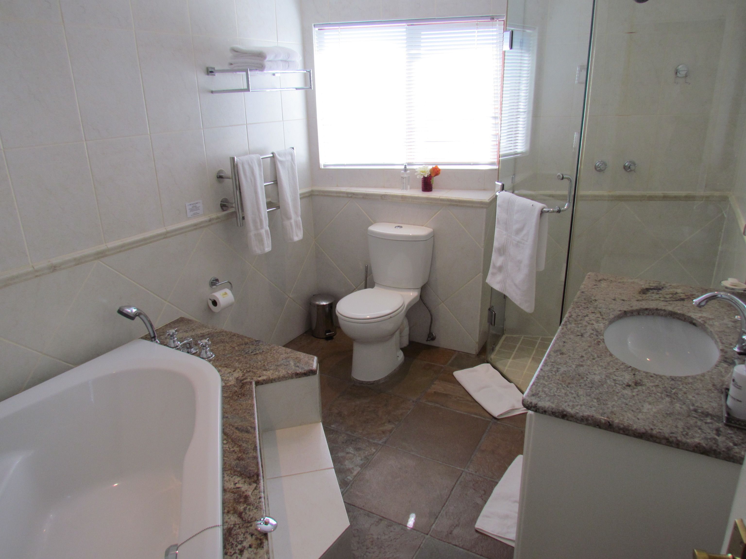 A bathroom with a bathtub, sink, toilet, and shower.