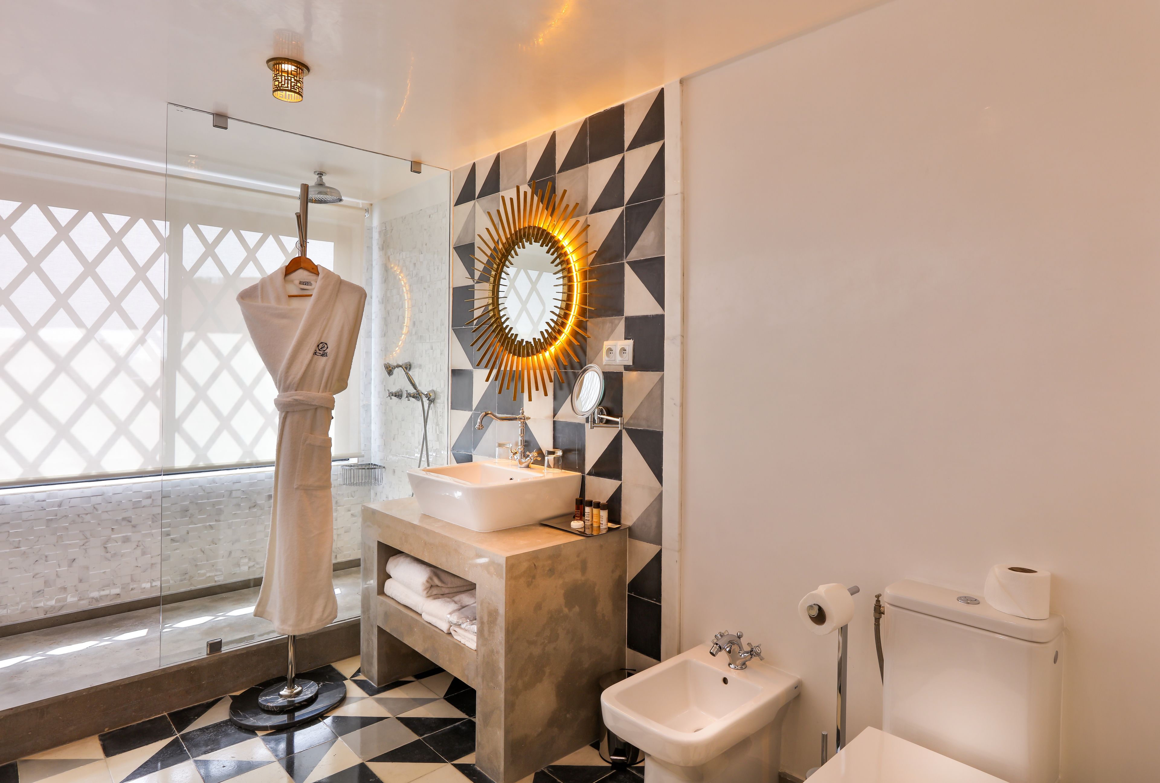 A modern bathroom with a glass shower enclosure, a vanity with a sink and mirror, and a toilet.