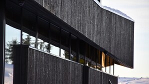 Um edifício moderno com fachada de madeira e janelas amplas.