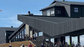 A modern ski lodge with a sloped roof and large windows.