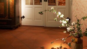 A room with a white door, a wooden cabinet, and a vase with flowers. - Hotel Weisses Ross (Dinkelsbuehl)