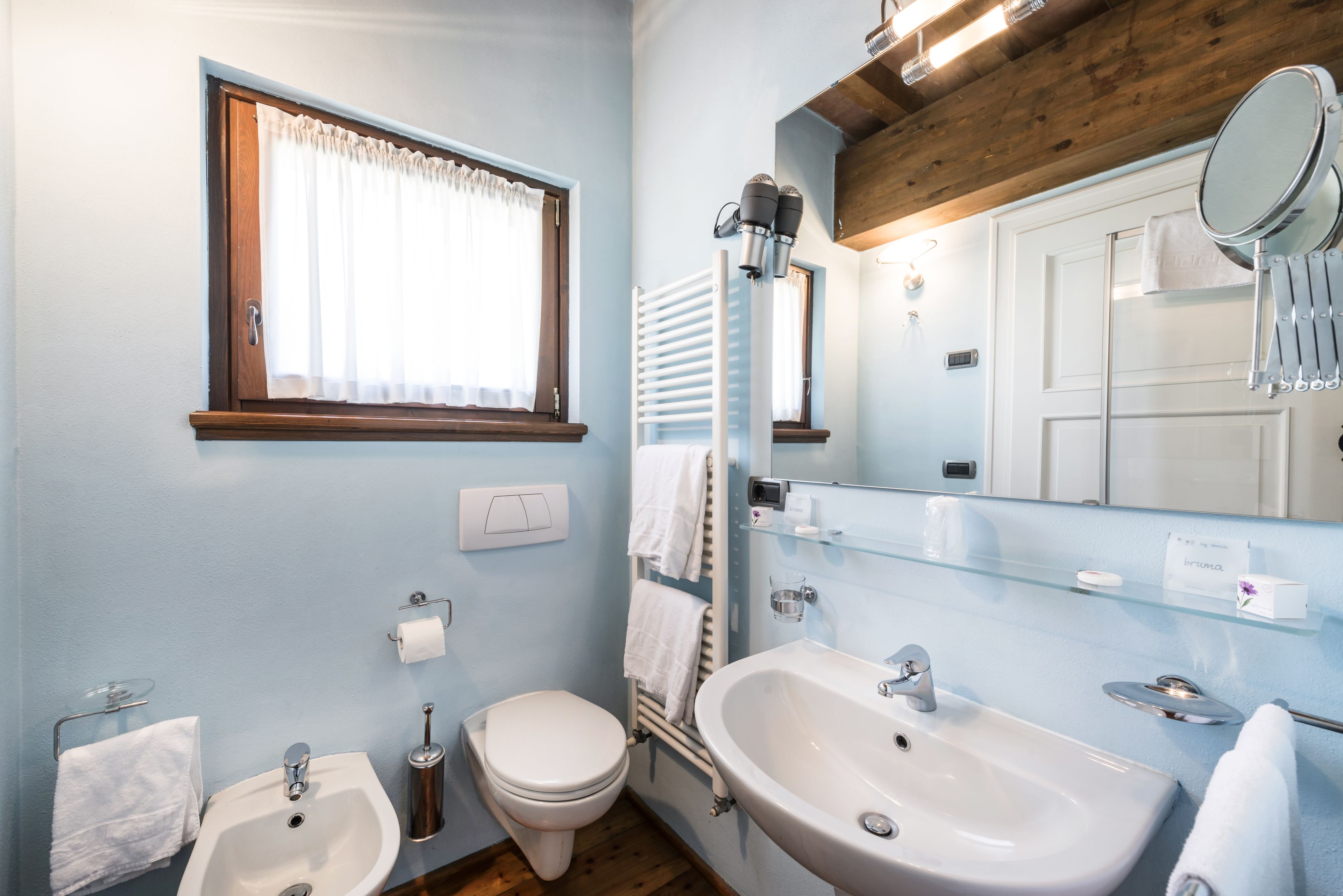 Une salle de bain équipée d’un bidet, de toilettes, d’un lavabo et d’un miroir au-dessus du lavabo.