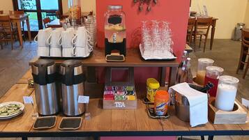 Una estación de café con varias cafeteras, una estación de té y diferentes condimentos.