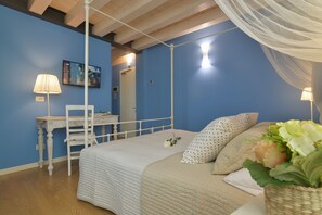 A bedroom with a four-poster bed, a bedside table, a lamp, and a mirror. - Casa Dei Racconti (Ceggia)