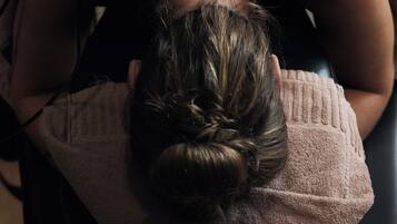 A person lying on a bed receiving a back treatment.