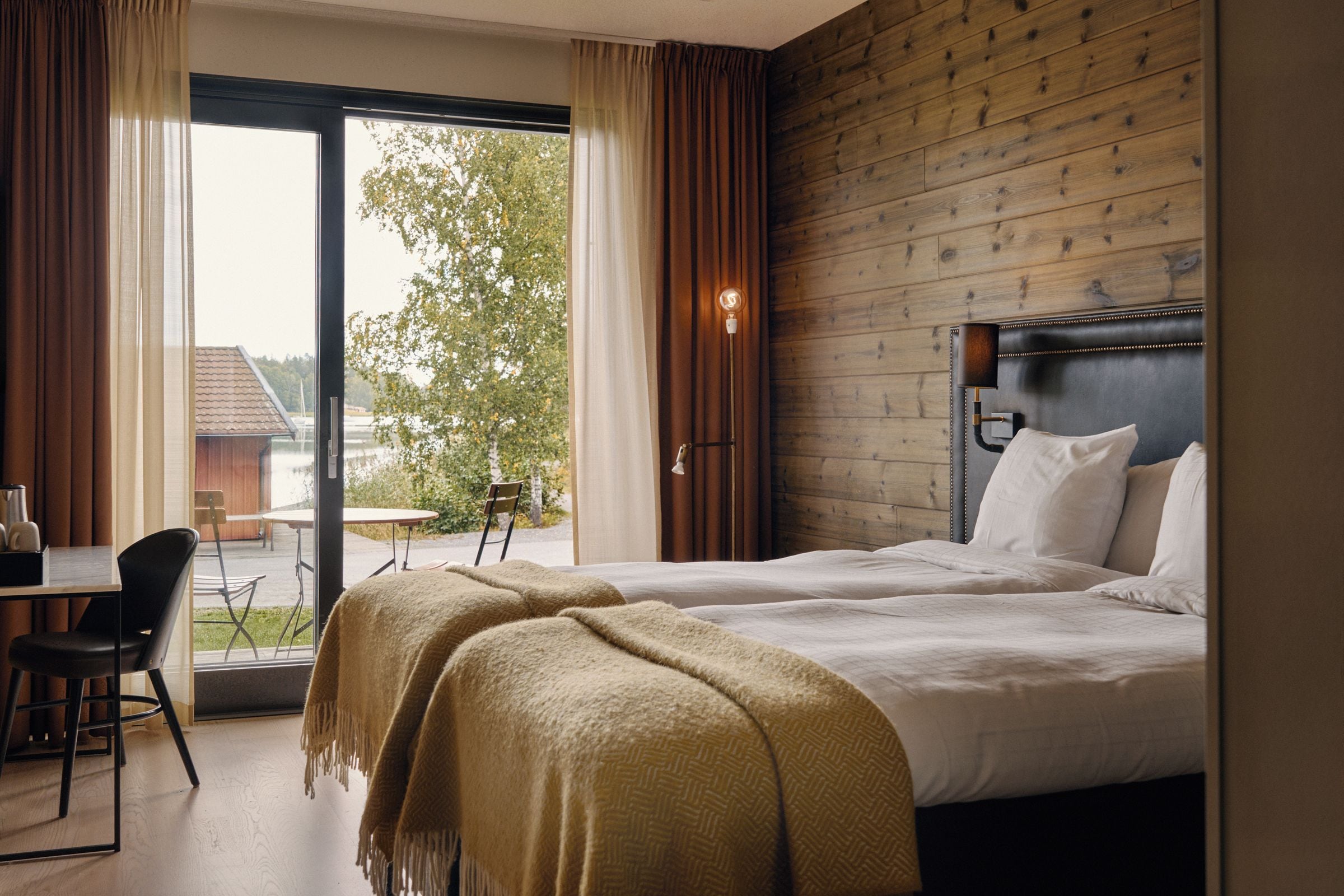 A hotel room with a bed, a desk, and a chair.