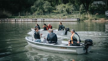 Un pequeño barco a motor con varias personas a bordo, incluyendo a una persona manejando.