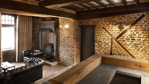 A cozy living room with a fireplace, leather sofas, and exposed brick walls. - Appart-Hotel Léopold Liège Centre (Liege)