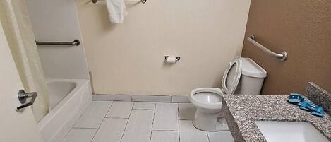A bathroom with a bathtub, toilet, and sink.