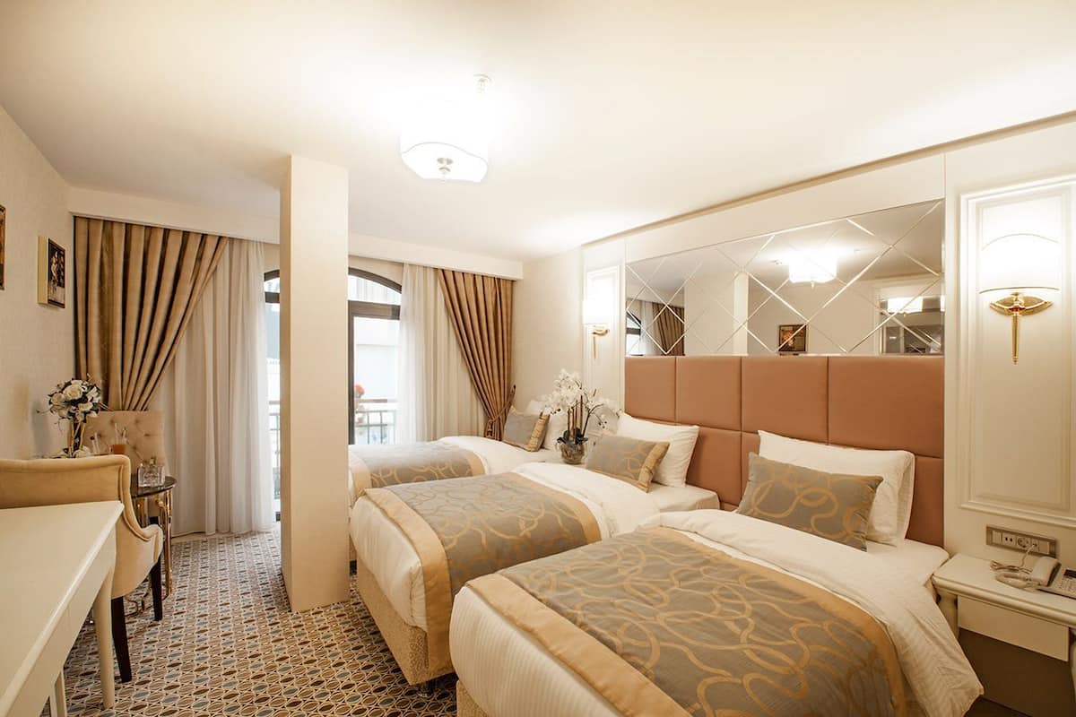 Deluxe driepersoonskamer, niet-roken, uitzicht op de stad | Luxe beddengoed, een minibar, een kluis op de kamer, een bureau