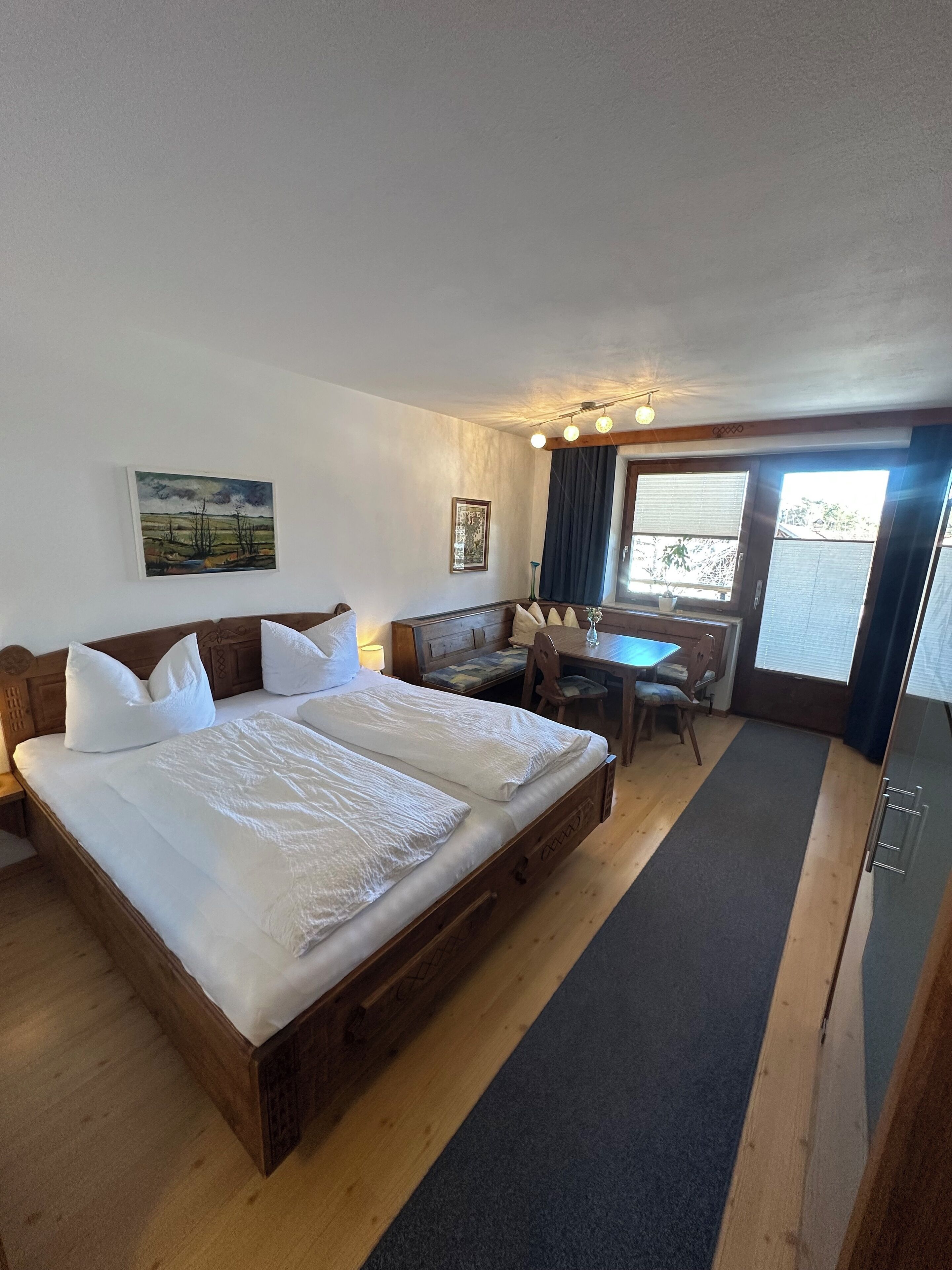 Ein Hotelzimmer mit zwei Betten, einem Schreibtisch, einem Stuhl und einem großen Fenster.