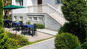 A two-story building with a balcony, outdoor seating, and a stone facade. - Villa Catelli B&B (Lucca)