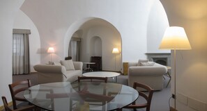 Ein modernes Wohnzimmer mit Glastisch, zwei Sofas und einem Kamin.