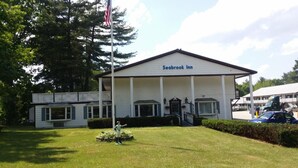 A Seabrook Inn with a white exterior, a porch, and a flagpole. - Seabrook Inn (Seabrook)