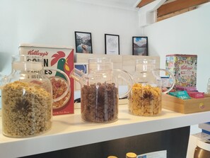 A breakfast bar with various cereals and a Kellogg's box. - ibis budget Chambéry Centre Ville (Chambery)